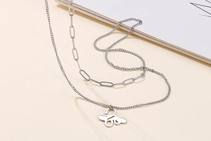 Detail of silver double-layered necklace featuring hollow butterfly pendants and metal chain