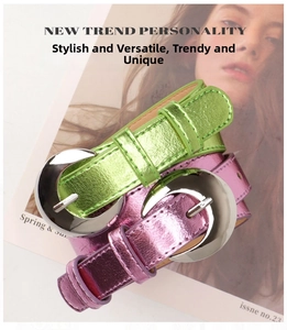 Detail of trendy belts with large silver crescent buckles in neon green and metallic pink