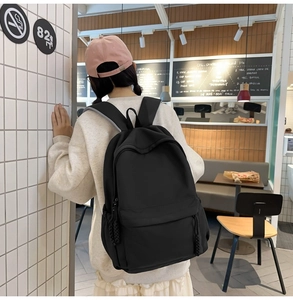 Rückansicht eines Models mit einem minimalistischen schwarzen Rucksack aus dichtem Stoff