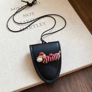 Detail of cute black leather sausage dog glasses holder necklace on a vintage book