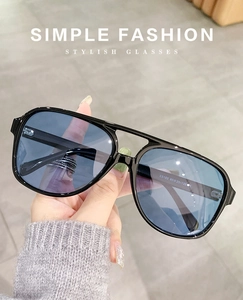 Detail view of double-bridge aviator sunglasses with blue gradient lenses and black frames