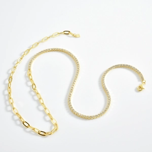 Detail of gold double-layered necklace featuring paperclip links and sparkling tennis chain