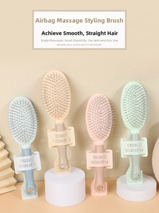 Detail of four colorful hairbrushes with ergonomic handles and massage bristle tips