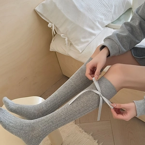 Detail of grey ribbed calf socks featuring a sweet satin ribbon bow on the side