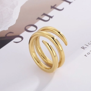 Detail of minimalist triple-layered gold spiral open ring on an artistic magazine page