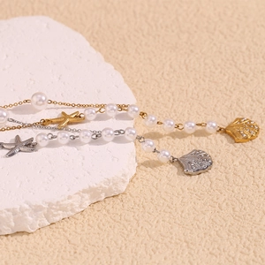 Detail of 18K gold-plated necklace with sea shell, starfish charms and white pearls