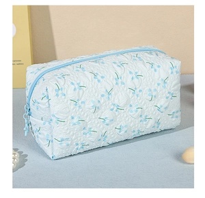 Detail of floral bubble fabric makeup bag with zipper closure and textured pattern