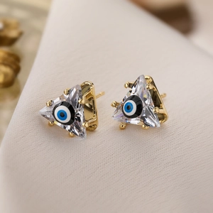 Nahaufnahme goldener Dreieck-Ohrstecker mit blauem Auge und Zirkon-Verzierungen