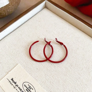 Detailed view of red matte hoop earrings with latch back closure in a gift box
