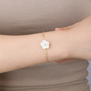 Elegant gold chain bracelet featuring a delicate white shell flower and pearl detail