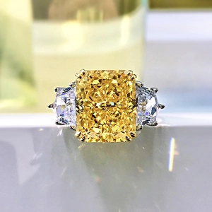 Macro shot of ice-flower cut yellow radiant gemstone ring with sparkling side stones