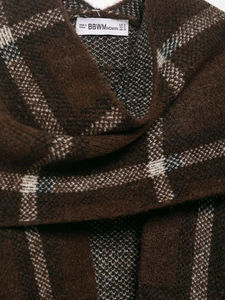 Close-up of brown plaid knitted coat fabric with brand label and soft wool texture