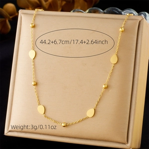 Golden stainless steel necklace with water drop pendant on a beige jewelry stand