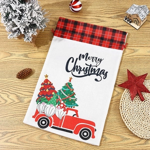 Flat lay of Merry Christmas drawstring gift bag with Santa and truck print on wood
