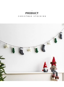 Detail of knitted Christmas stockings and stars hanging on a wall with gnome decorations