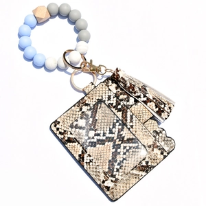 Macro detail of snakeskin pattern PU leather card holder with tassel and silicone beads