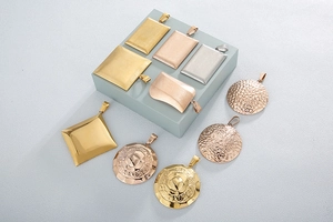 Detail of square and round stainless steel pendants in gold, silver and rose gold