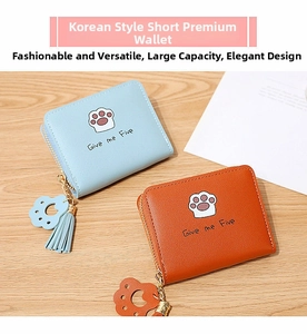 Détail de porte-monnaie courts en cuir PU avec illustration de patte de chat et pompon