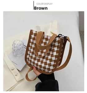 Detail of a brown plaid canvas tote bag with woven handles and adjustable shoulder strap