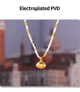 Macro detail of gold shell pendant and beaded necklace with PVD electroplating finish