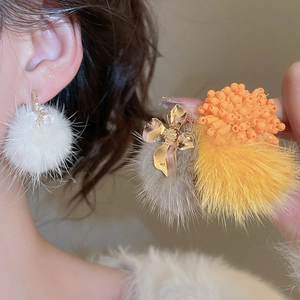 Detail of floral metal studs with soft plush fur ball pendants in various colors