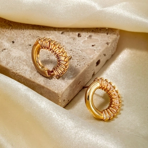 Elegant gold plated hoop earrings with rectangular cubic zirconia on silk background
