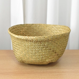 Macro detail of natural straw woven basket showing textures on a light wood tabletop