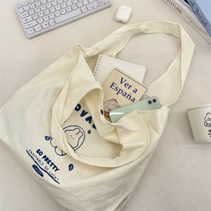 Interior view of off-white canvas tote showing capacity for books and smartphone