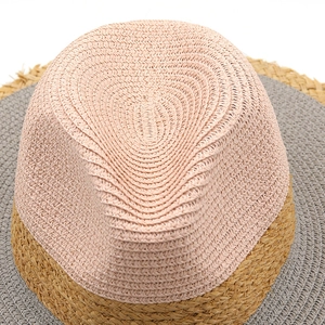 Vista dettagliata della trama in paglia intrecciata e del design bicolore del cappello