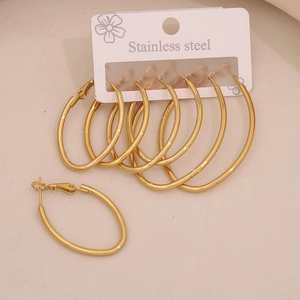 Three pairs of gold stainless steel oval hoop earrings on a white professional display card