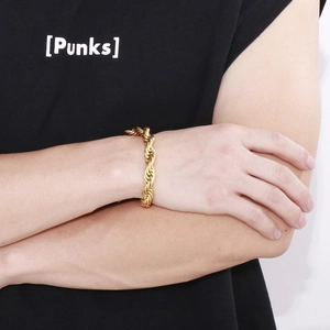 Dettaglio del bracciale a catena intrecciata dorata da uomo indossato sul polso