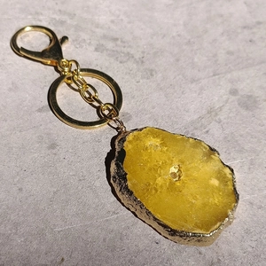 Detailed close-up of yellow agate stone keychain with elegant gold-plated metal edges