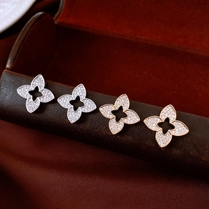 Macro detail of gold plated flower stud earrings with sparkling cubic zirconia inlay