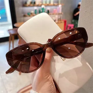 Cat-eye tea brown polarized sunglasses with UV protection in a handheld view