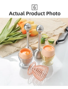 Set of stainless steel egg shell openers and spiral egg holders on marble surface
