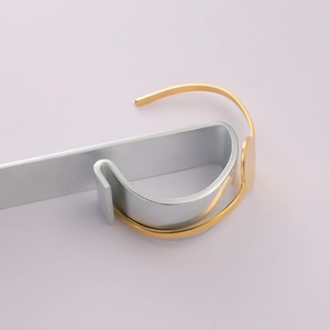 Detail of a gold adjustable cuff bracelet with a round bezel tray on a silver metal stand