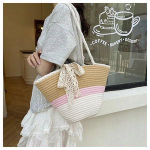 Détail d'un sac bandoulière tissé tricolore avec nœud en dentelle et bandoulière torsadée