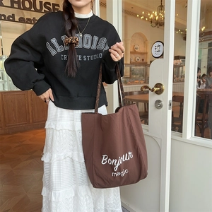 Brown tote bag with Bonjour magic print and leopard straps shown on a model