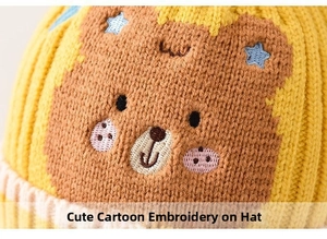 Close-up of yellow baby knit hat with bear cartoon embroidery and blue star detail