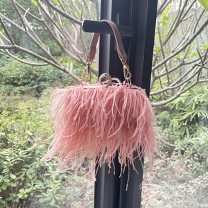 Detail of pink ostrich feather clutch with crystal clasp and golden chain strap
