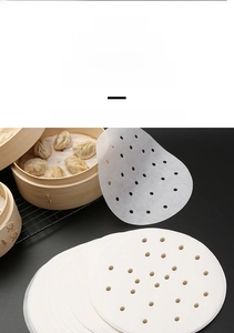 Close-up of food-grade round perforated steamer paper liners for non-stick bamboo steamers