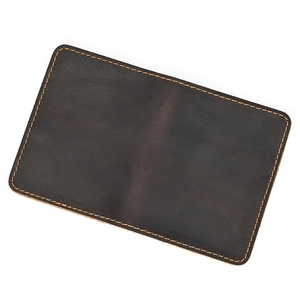 Close-up of vintage dark brown genuine leather coin purse with yellow stitching detail