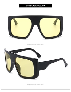 Detail view of oversized flat top sunglasses in black and yellow for street style