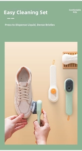 Close-up of a liquid dispensing shoe brush cleaning a white sneaker with soft bristles.