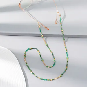 Detail of beaded eyewear chain with green crystals and gold heart-shaped metal charms
