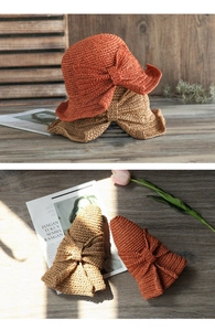 Detalle de sombreros de paja plegables con lazos grandes en colores naranja y caqui