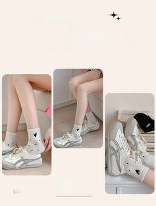 Detail showing white socks with black heart patterns paired with retro lace-up sneakers
