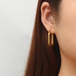 Vintage style rectangular gold stainless steel hoop earrings worn by a model