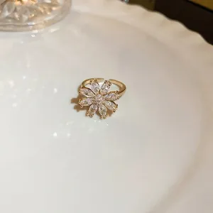 Exquisite gold-plated daisy ring with crystal petals and pavé zircon center on a plate