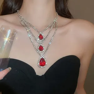 Collana a tre strati con pendenti a goccia rossi e diamanti su modella elegante